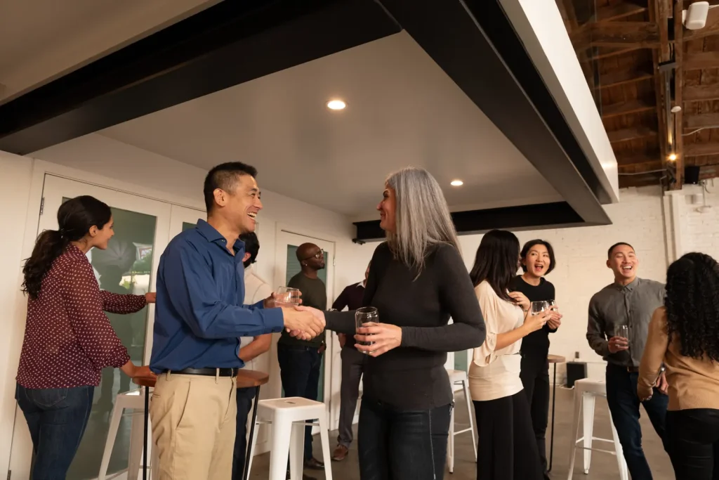 Members greet each other with handshakes and smiles before a meeting