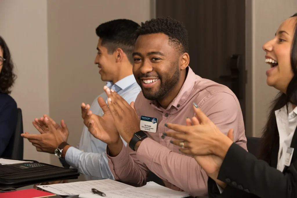 Members applaud a speaker at a Toastmasters meeting